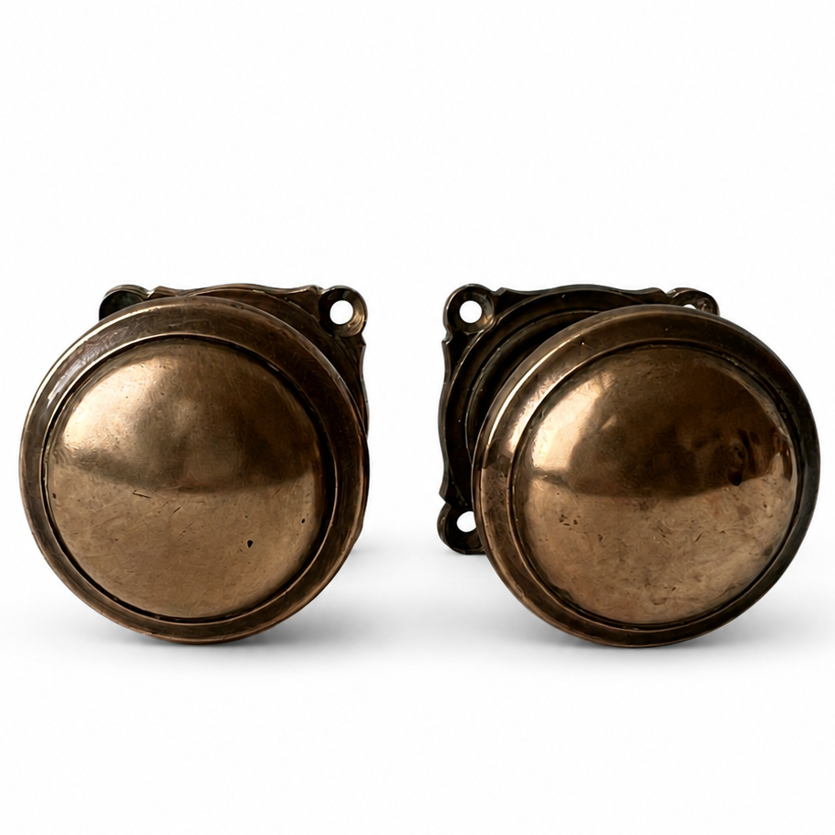 Pair of heavy antique cast brass door knobs with round handles, square backplates